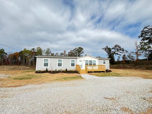manufactured / mobile home featuring a wooden deck and driveway