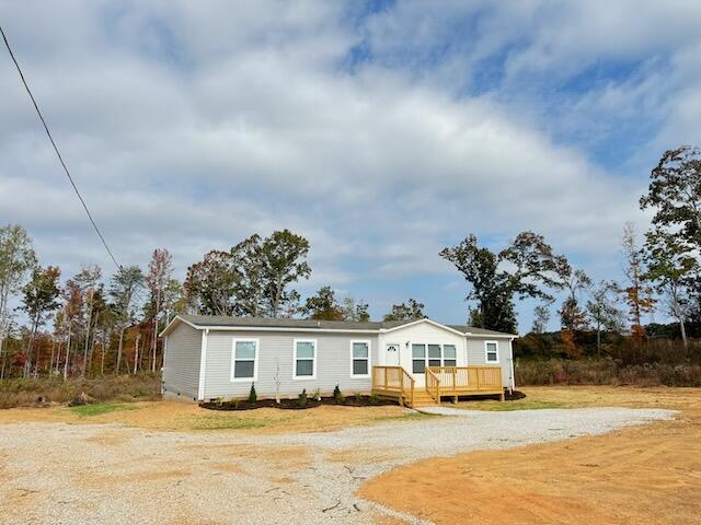 manufactured / mobile home with a deck and gravel driveway