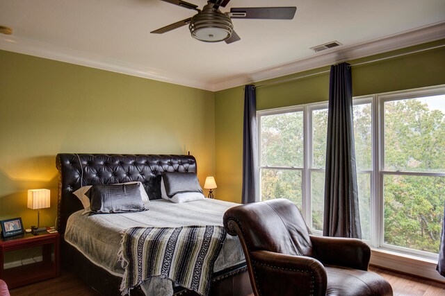 bedroom with ornamental molding, wood-type flooring, and ceiling fan