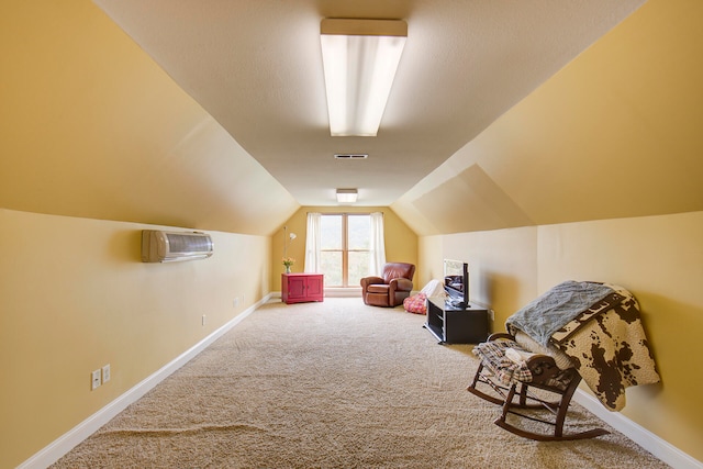 additional living space with carpet flooring, lofted ceiling, and a wall unit AC