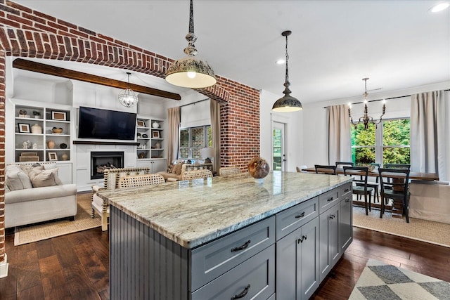 kitchen with a wealth of natural light, a kitchen island, gray cabinetry, and decorative light fixtures