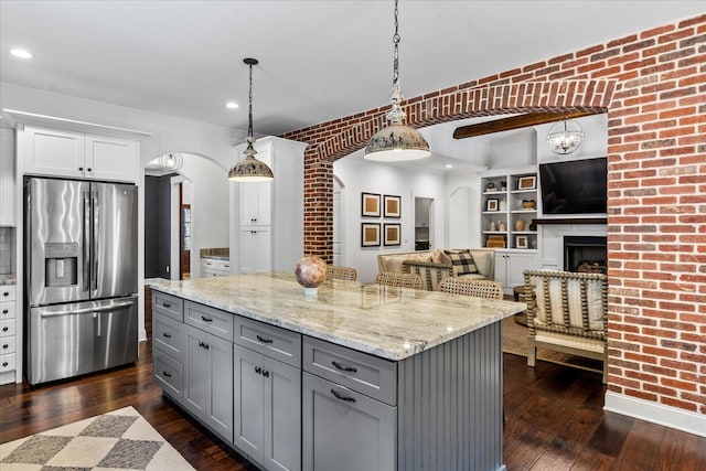 kitchen featuring dark wood-type flooring, hanging light fixtures, gray cabinets, and stainless steel fridge