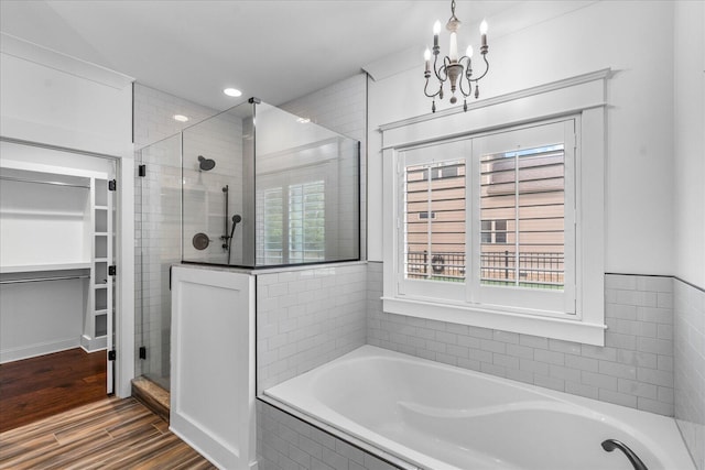 bathroom featuring separate shower and tub, a chandelier, and hardwood / wood-style flooring