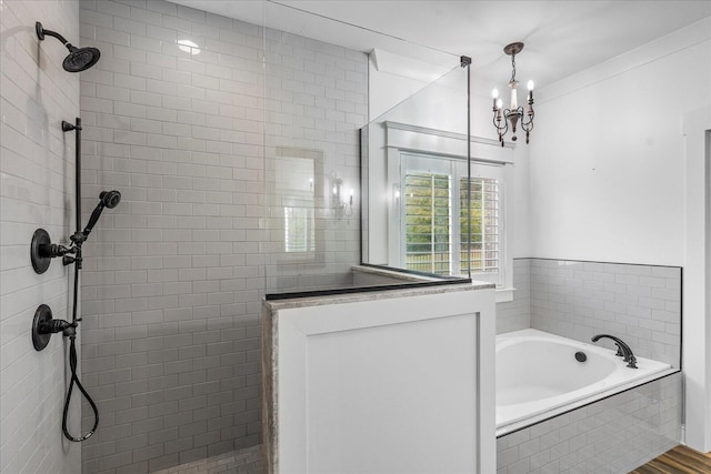 bathroom featuring a notable chandelier and separate shower and tub