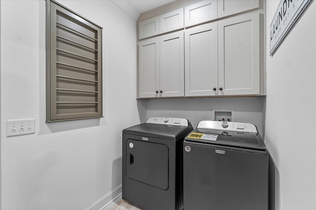 washroom featuring light hardwood / wood-style flooring, independent washer and dryer, and cabinets