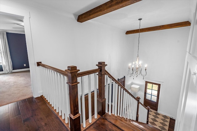 stairway featuring an inviting chandelier, hardwood / wood-style floors, and beam ceiling