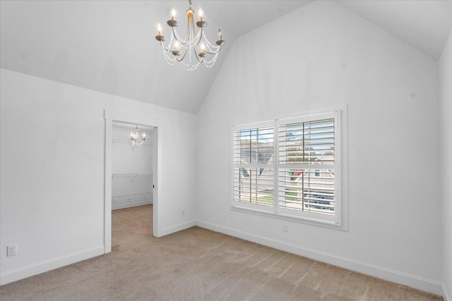 carpeted empty room with lofted ceiling and a notable chandelier