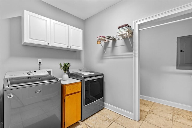 washroom with cabinets, electric panel, washer and dryer, and light tile patterned floors