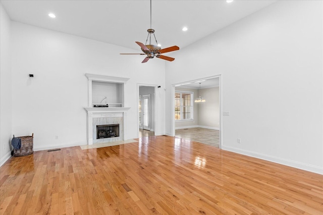 unfurnished living room featuring ceiling fan, light hardwood / wood-style floors, and a tile fireplace