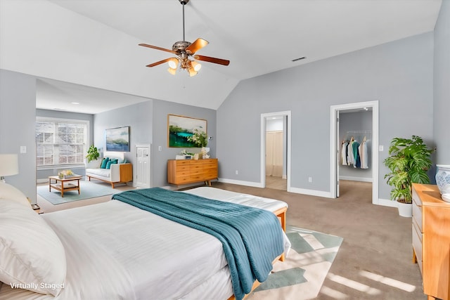 carpeted bedroom with vaulted ceiling, a spacious closet, ceiling fan, ensuite bath, and a closet