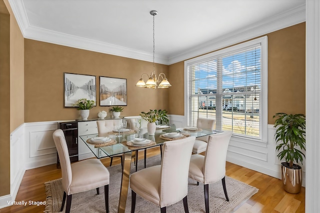 dining room with a notable chandelier, crown molding, light hardwood / wood-style floors, and beverage cooler