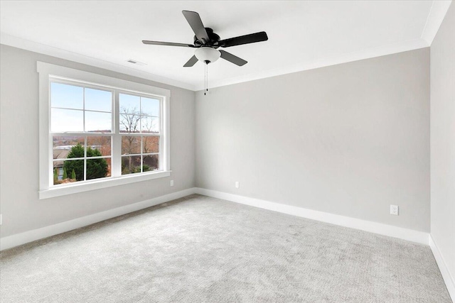 carpeted spare room with crown molding, baseboards, visible vents, and ceiling fan