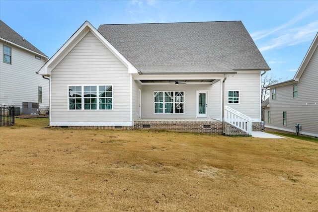 rear view of house featuring ceiling fan, a lawn, and central AC unit