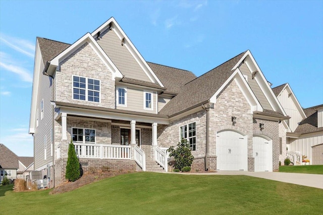 craftsman-style house featuring covered porch, driveway, a front lawn, and stone siding