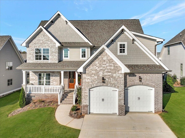 craftsman house featuring a porch, a front yard, roof with shingles, concrete driveway, and stone siding