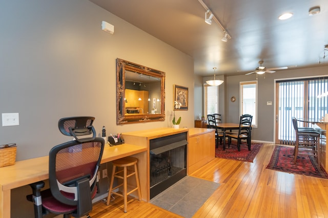 office with hardwood / wood-style floors, track lighting, and ceiling fan