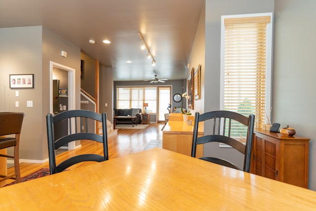 dining area with rail lighting, ceiling fan, and hardwood / wood-style floors