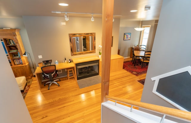 office area with rail lighting and hardwood / wood-style floors