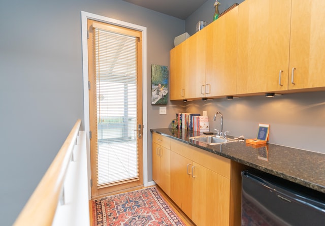 kitchen with light brown cabinetry, sink, dark stone counters, and dishwasher