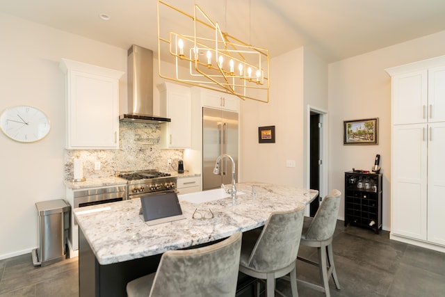 kitchen featuring backsplash, wall chimney exhaust hood, decorative light fixtures, white cabinets, and high end appliances