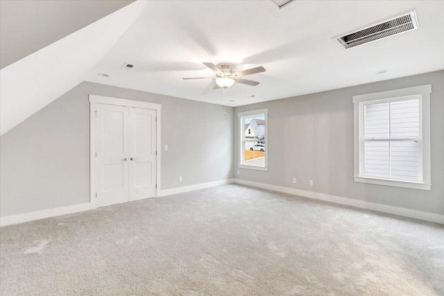 bonus room featuring vaulted ceiling, light carpet, and ceiling fan