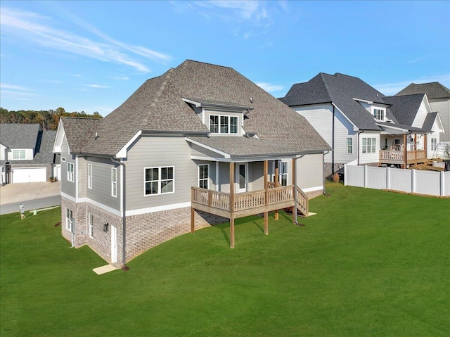 rear view of property with roof with shingles, fence, and a yard