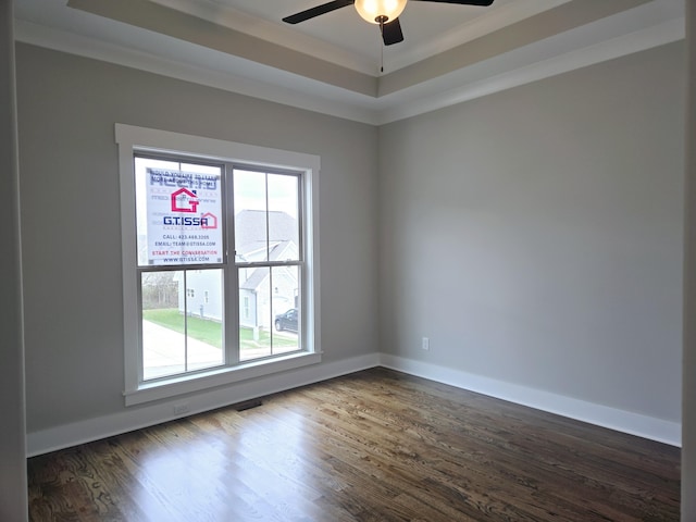 unfurnished room featuring dark hardwood / wood-style flooring, ceiling fan, a raised ceiling, and crown molding