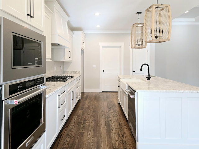 kitchen featuring light stone countertops, sink, stainless steel appliances, pendant lighting, and white cabinets