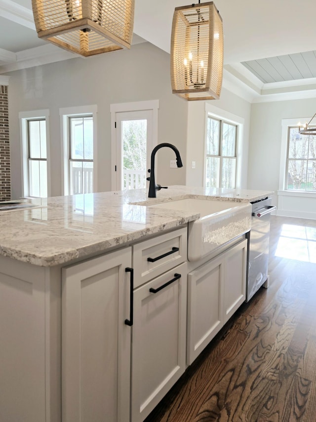 kitchen featuring sink, white cabinets, stainless steel dishwasher, and decorative light fixtures