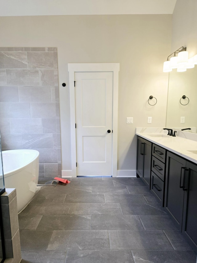 bathroom with vanity, a tub to relax in, and tile walls