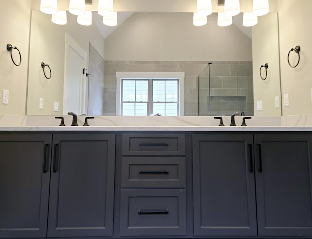 bathroom with a shower, vanity, and vaulted ceiling