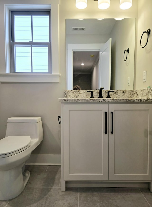 bathroom with tile patterned flooring, vanity, and toilet