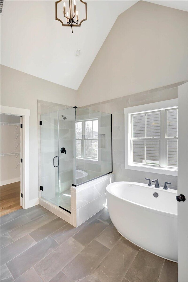 bathroom with plus walk in shower, a chandelier, and high vaulted ceiling