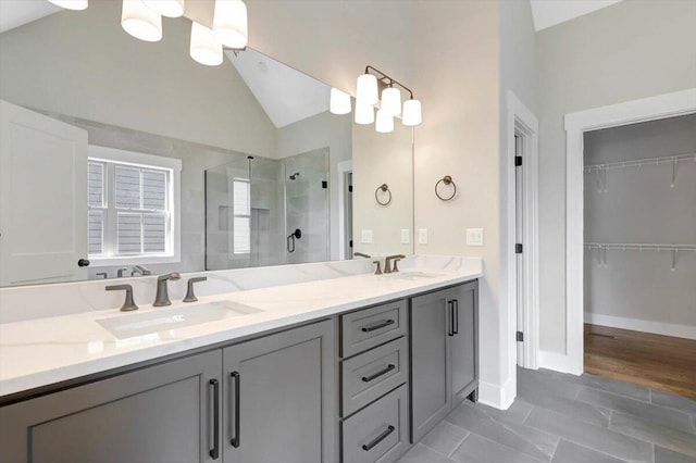 bathroom featuring lofted ceiling, vanity, a notable chandelier, and an enclosed shower