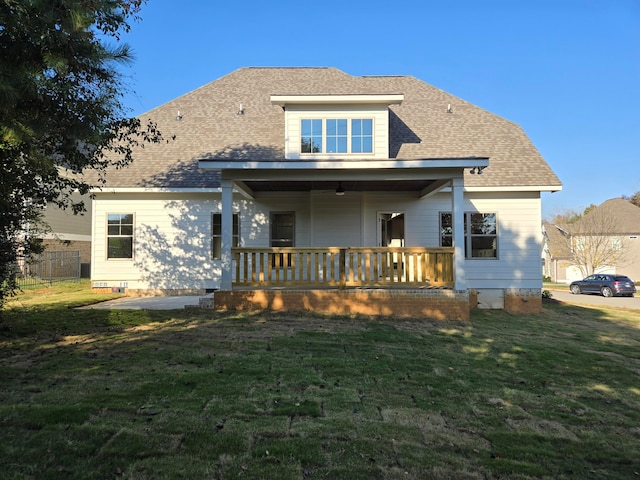 rear view of property featuring a yard, a patio area, and a porch