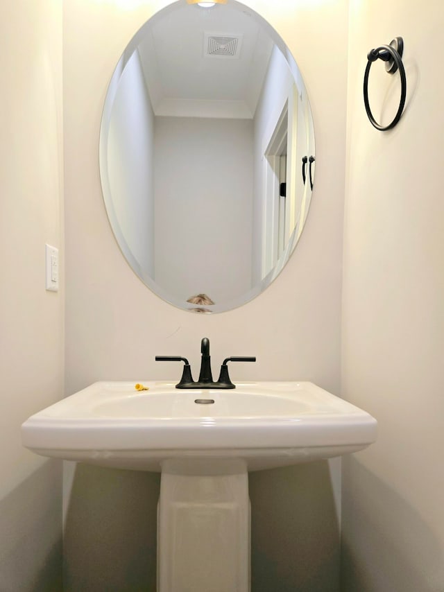 bathroom featuring sink and crown molding