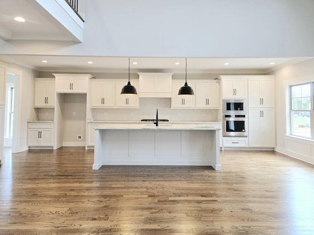 kitchen featuring appliances with stainless steel finishes, decorative light fixtures, and white cabinets