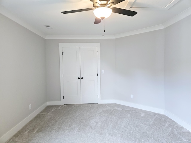 unfurnished bedroom with carpet floors, ornamental molding, a closet, and ceiling fan