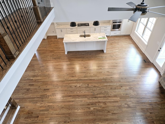 interior details featuring wood-type flooring, oven, and ceiling fan