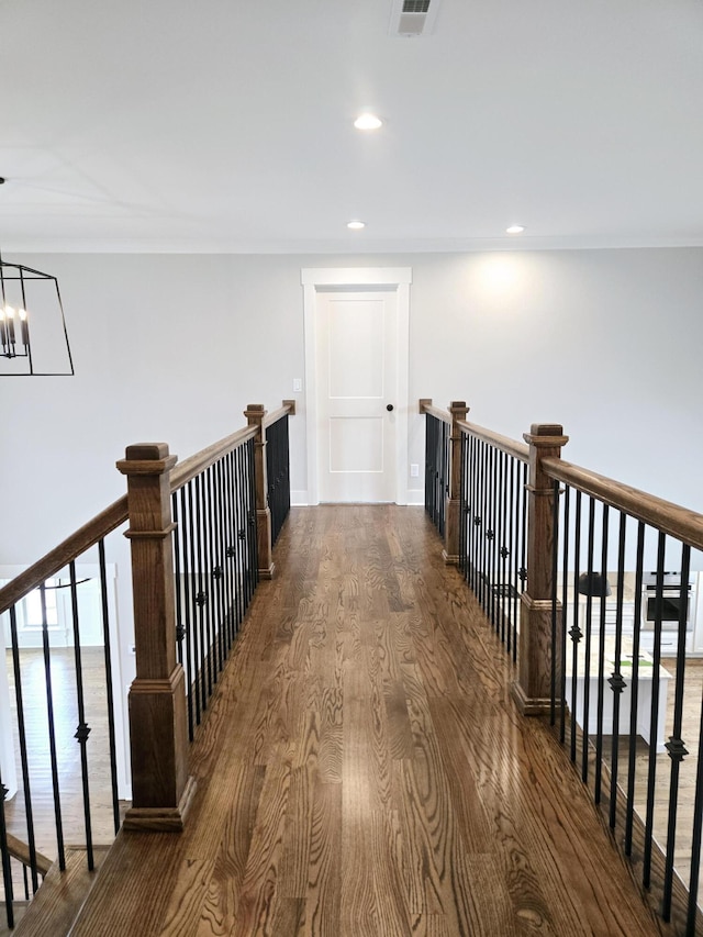 hall with dark hardwood / wood-style floors and a chandelier