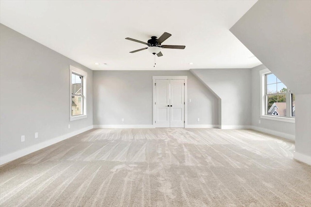 bonus room featuring ceiling fan and light colored carpet