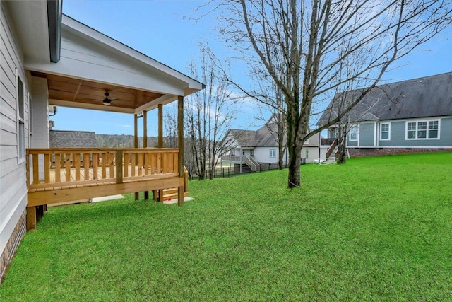 view of yard with ceiling fan and a deck