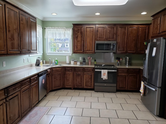 kitchen with sink, crown molding, dark brown cabinetry, light tile patterned floors, and appliances with stainless steel finishes