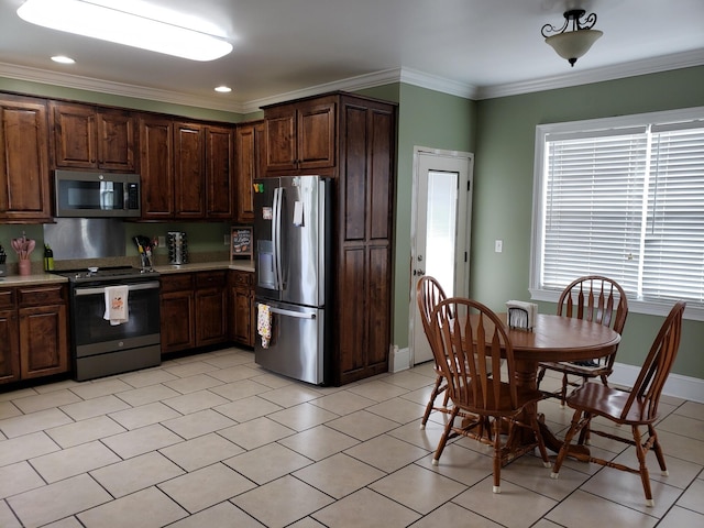 kitchen featuring dark brown cabinets, appliances with stainless steel finishes, and ornamental molding