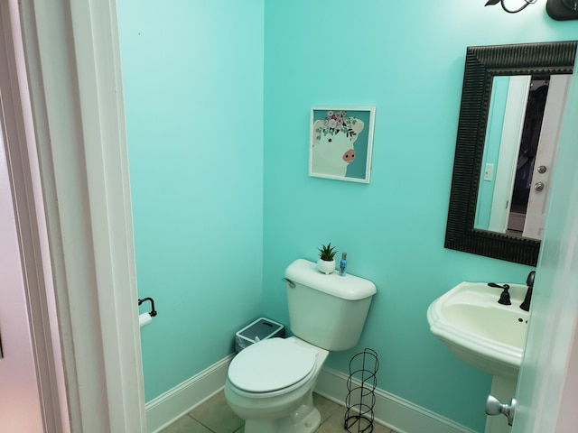 bathroom featuring toilet, sink, and tile patterned flooring