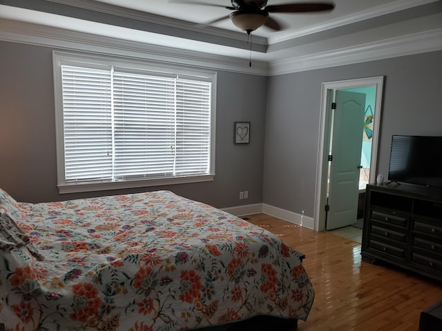 bedroom featuring ornamental molding, multiple windows, light hardwood / wood-style floors, and ceiling fan