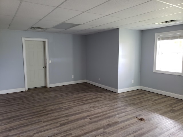 unfurnished room featuring hardwood / wood-style flooring and a drop ceiling