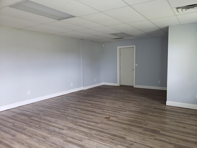 empty room with a drop ceiling and hardwood / wood-style flooring