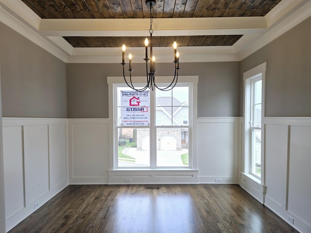 unfurnished dining area featuring plenty of natural light, dark hardwood / wood-style floors, crown molding, and an inviting chandelier