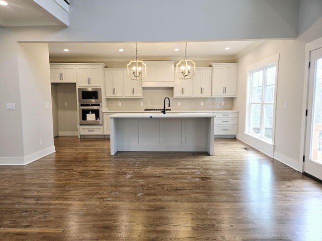 kitchen featuring white cabinetry, an island with sink, appliances with stainless steel finishes, and tasteful backsplash